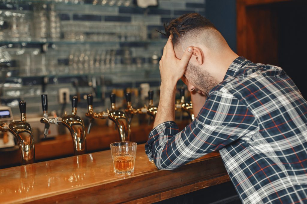 Lonely man drinking after addiction transference.