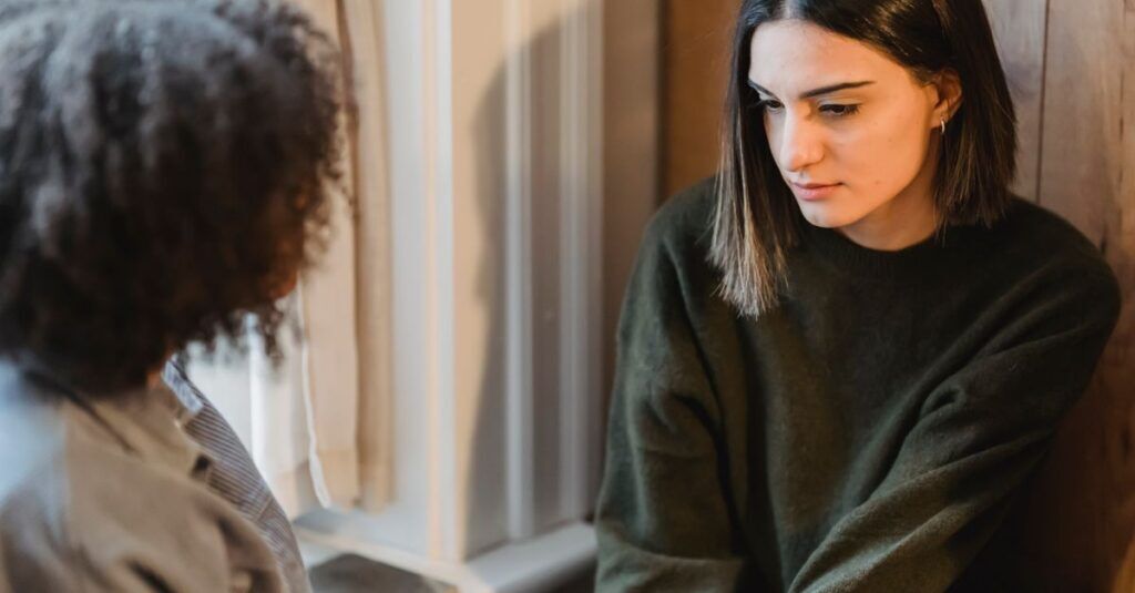 From above of crop anonymous female listening friend sharing news at home in daytime